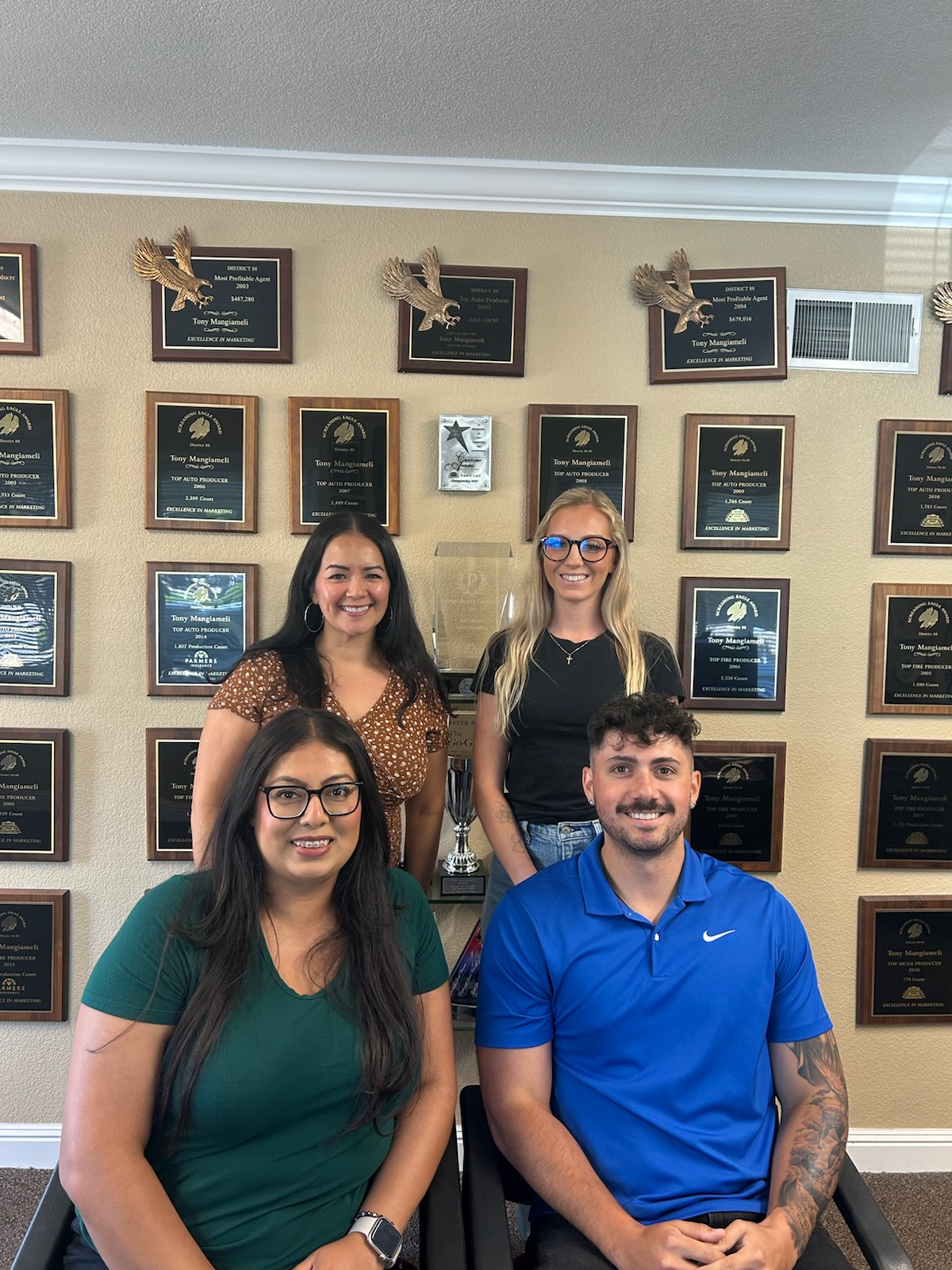 Anthony Mangiameli's Farmers Insurance team in San Jose, in front of their award wall